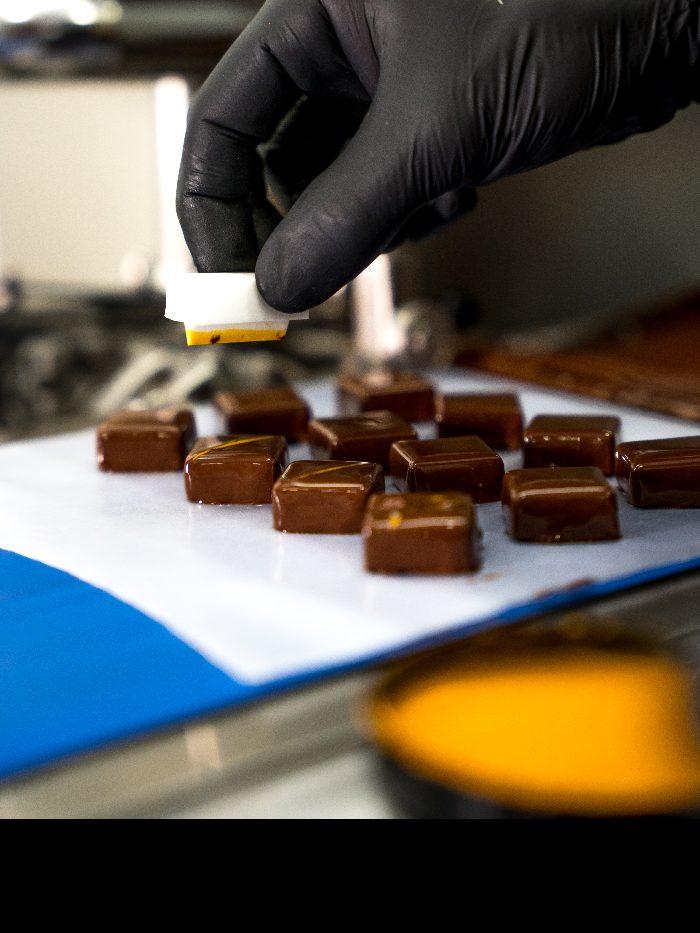 Enrobage des chocolats dans notre atelier de Servian