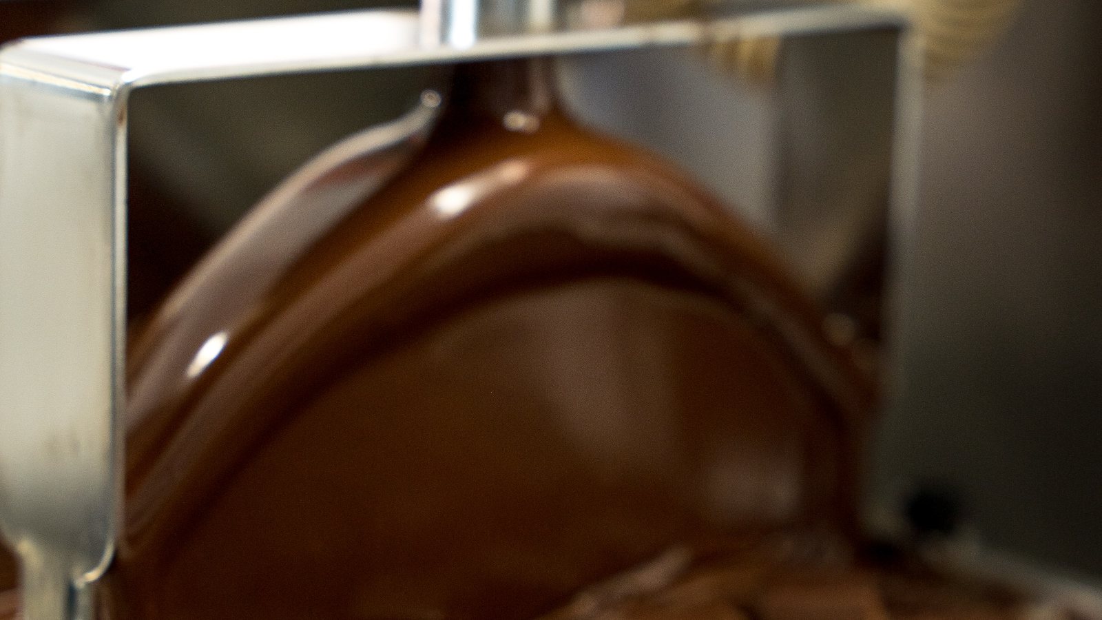 Rideau de chocolat Cacao-Trace sur la ligne d'enrobage, atelier Geoffrey Gil